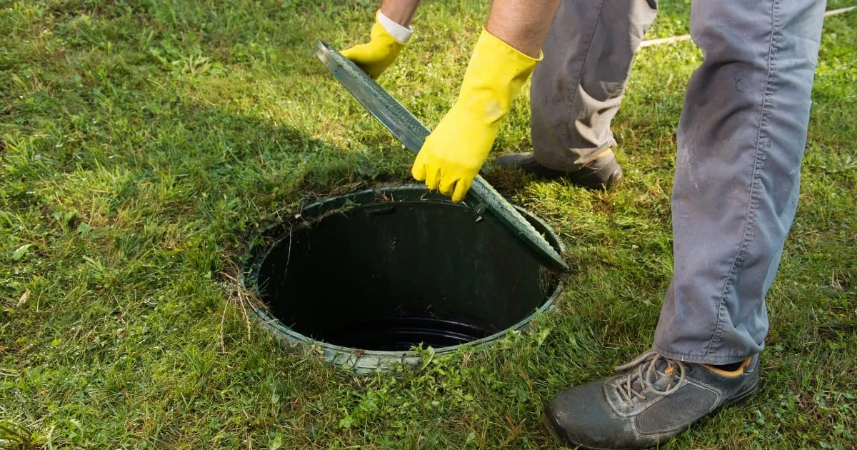 a person opening the septic tank cover