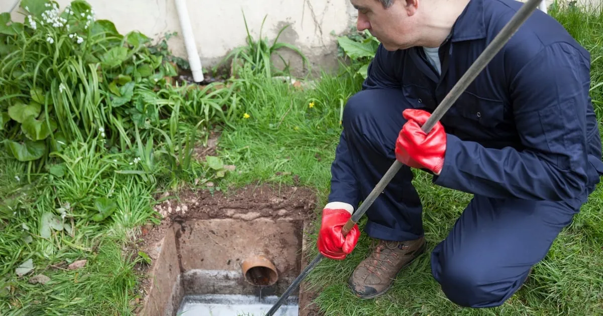 A plumber fixing a clogged sink in a modern kitchen. Expert Blocked Drains Services