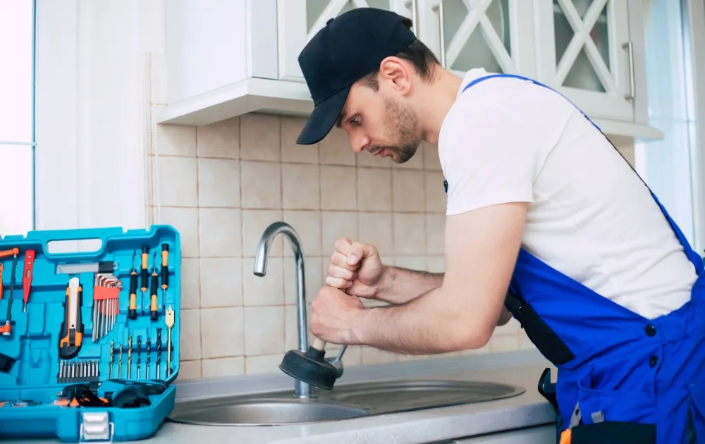 a professional plumber fixing the blocked drain