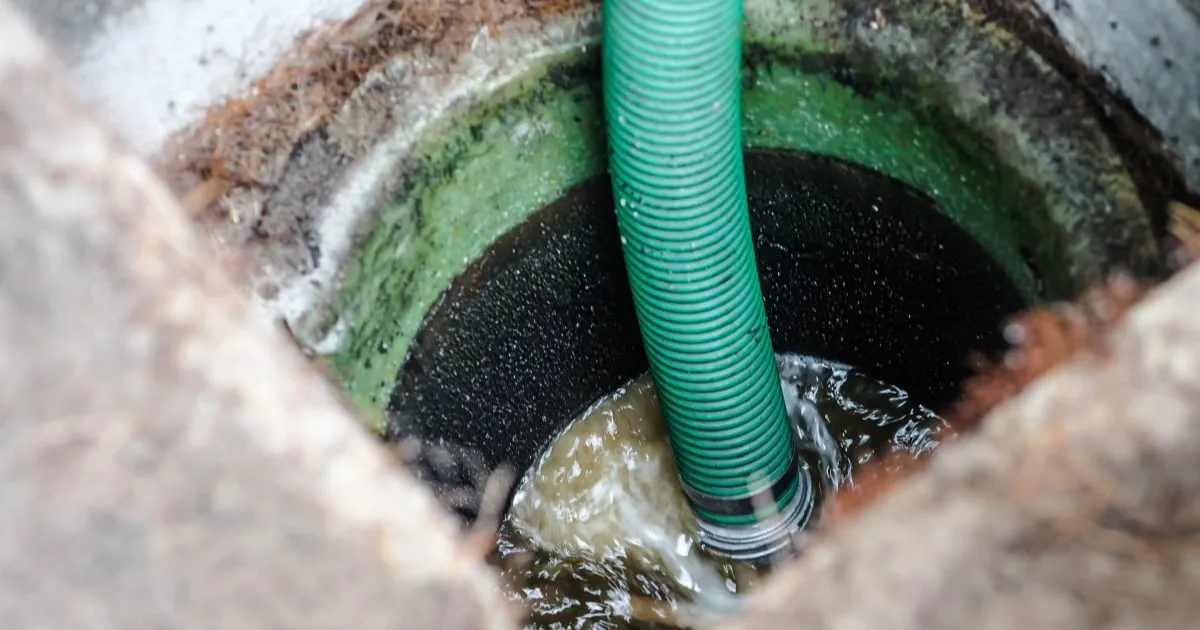 a dirty septic tank being cleaned with a plumbing tube