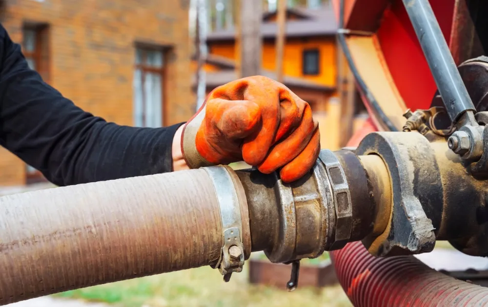 a hand wearing gloves connecting the tube in the truck