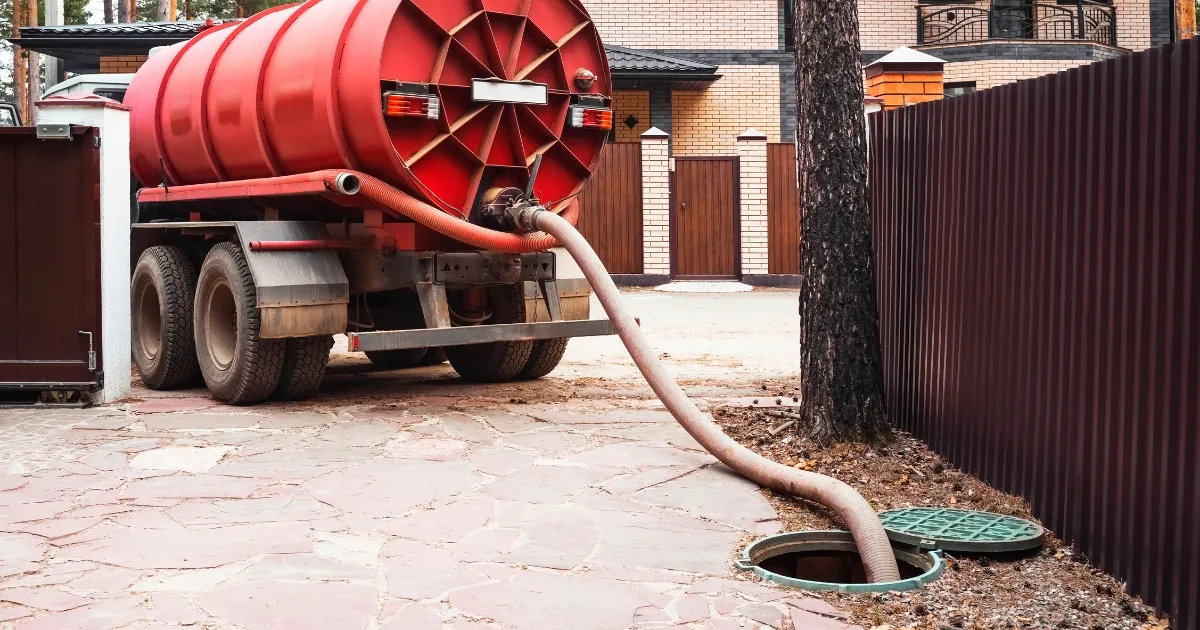 A plumber is maintaining a septic tank in a lush green environment. Why Choose Our Septic Tank Services