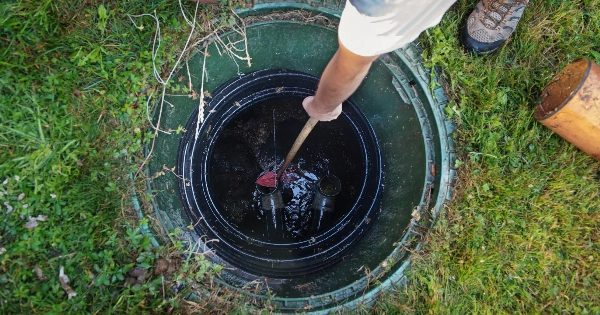 A plumber inspecting a well-maintained septic tank in a backyard. Why Proper Septic Tank Maintenance is Important
